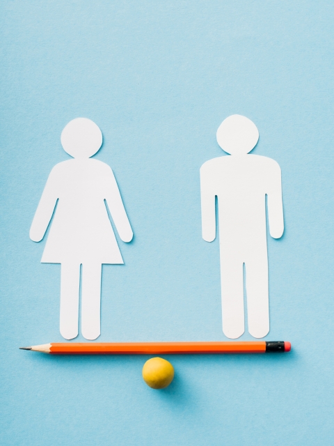 paper figures of couple as gender equality on pencil with ball isolated on blue, sexual equality